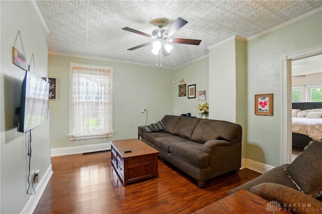 living room with baseboards, ceiling fan, ornamental molding, and wood finished floors