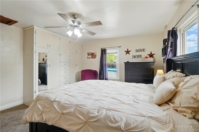 carpeted bedroom featuring baseboards and a ceiling fan