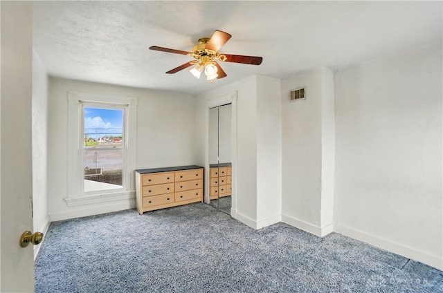 unfurnished bedroom featuring visible vents, a closet, baseboards, ceiling fan, and carpet