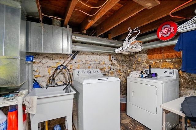 washroom featuring laundry area, washing machine and dryer, and a sink
