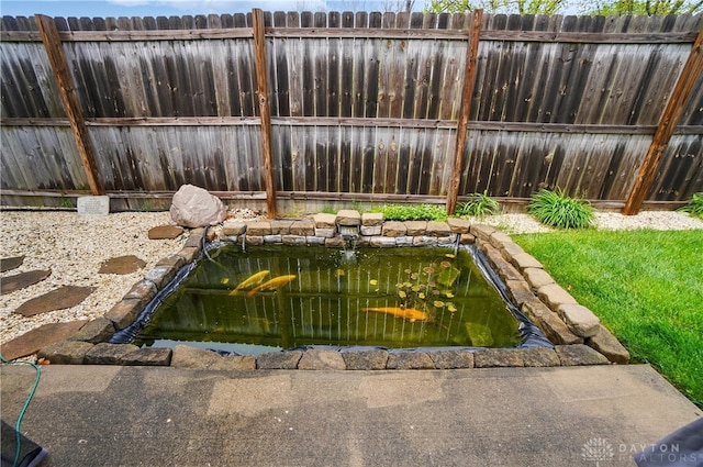 exterior space featuring a small pond and fence