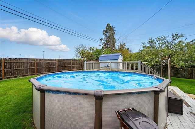 view of pool featuring a fenced in pool, a fenced backyard, a yard, and a deck