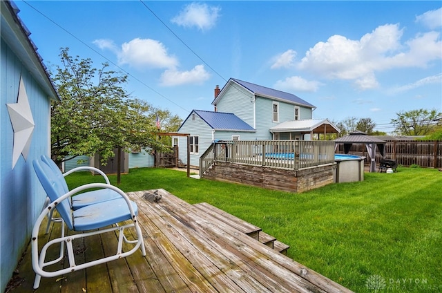 wooden deck featuring a fenced in pool, a gazebo, a lawn, and a fenced backyard