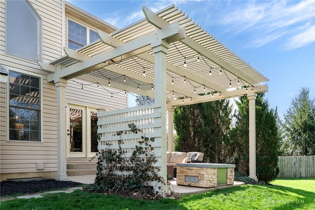 view of patio / terrace featuring fence, a pergola, and an outdoor kitchen