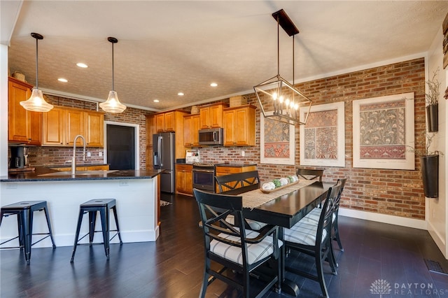 dining room featuring baseboards, recessed lighting, dark wood finished floors, and brick wall