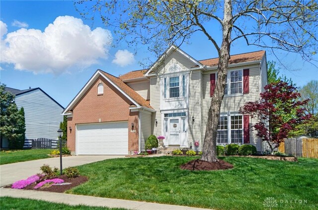 view of front facade featuring fence, an attached garage, brick siding, a front yard, and driveway
