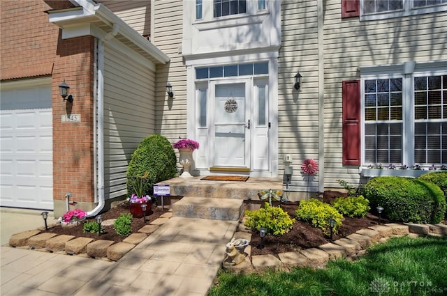 doorway to property featuring brick siding and a garage