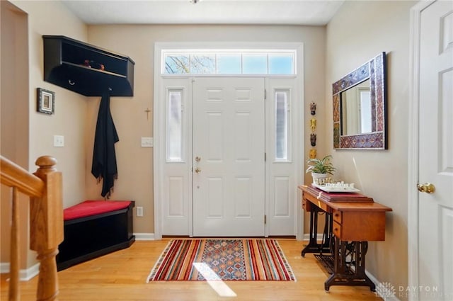 entryway with baseboards and light wood-style flooring