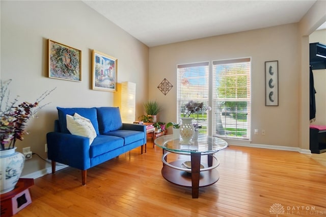 living area with baseboards and light wood finished floors