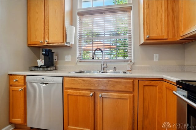 kitchen with a sink, light countertops, range, and dishwasher