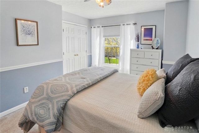 bedroom with carpet floors, baseboards, and a closet