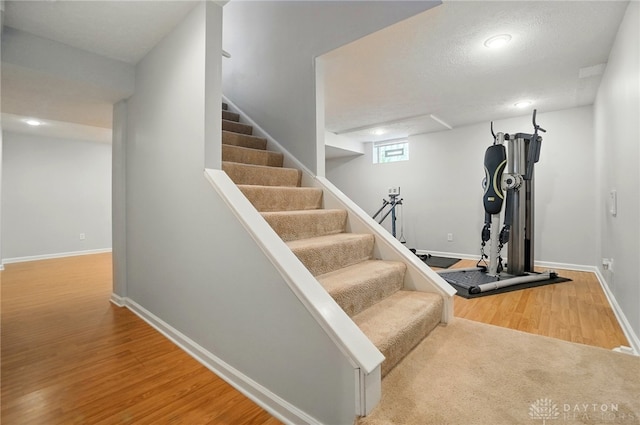 staircase with baseboards, recessed lighting, and wood finished floors