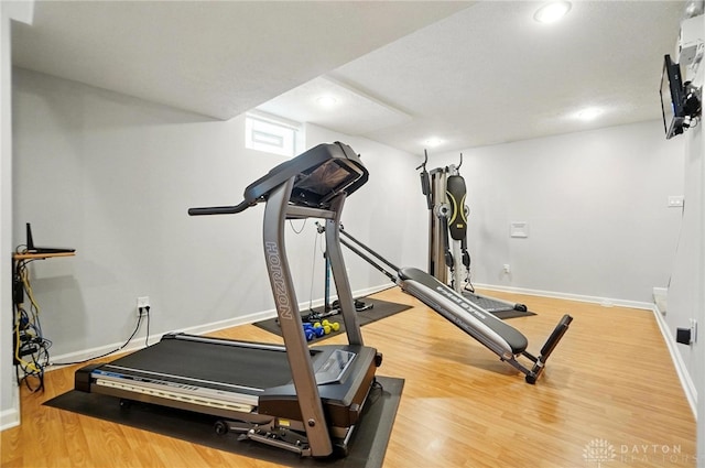 workout room featuring baseboards, recessed lighting, and wood finished floors