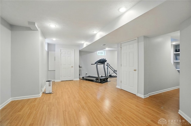 exercise area featuring recessed lighting, baseboards, and light wood-style flooring