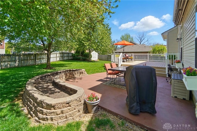 view of patio featuring a storage shed, a wooden deck, a fenced backyard, an outbuilding, and outdoor dining area