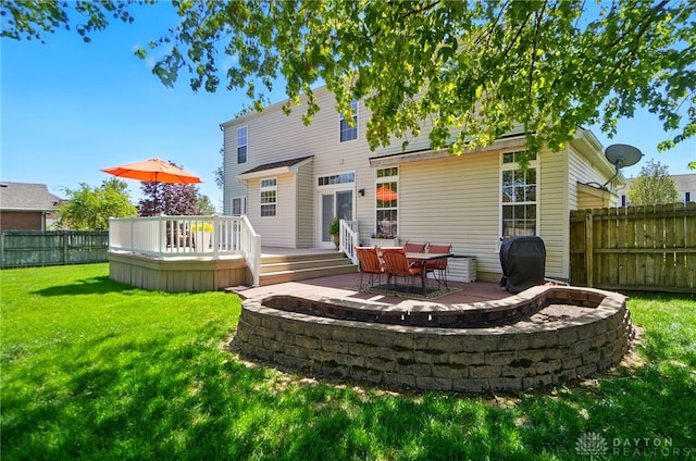 rear view of house featuring a fenced backyard, a lawn, and a deck