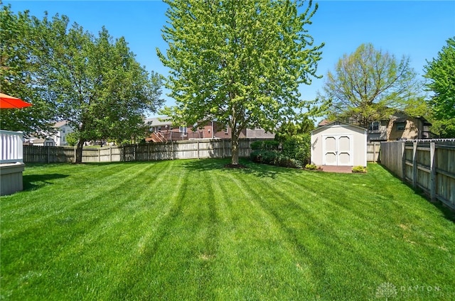 view of yard with an outbuilding, a shed, and a fenced backyard