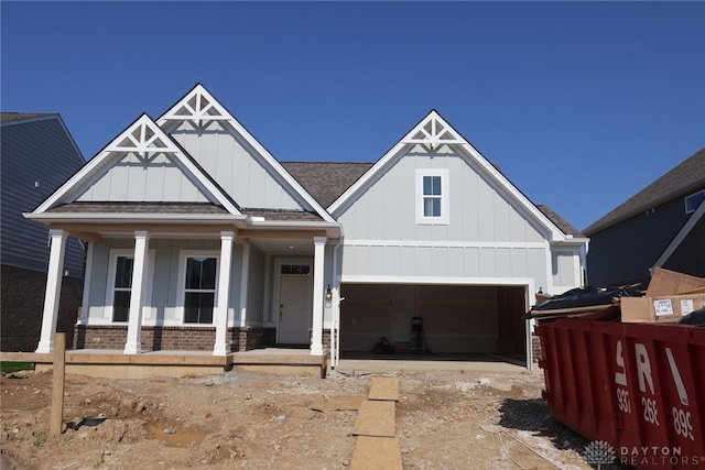 2885 Sky Crossing Dr Unit 56, Beavercreek, OH 45434 - view of front of house featuring board and batten siding, brick siding, a garage, and a porch