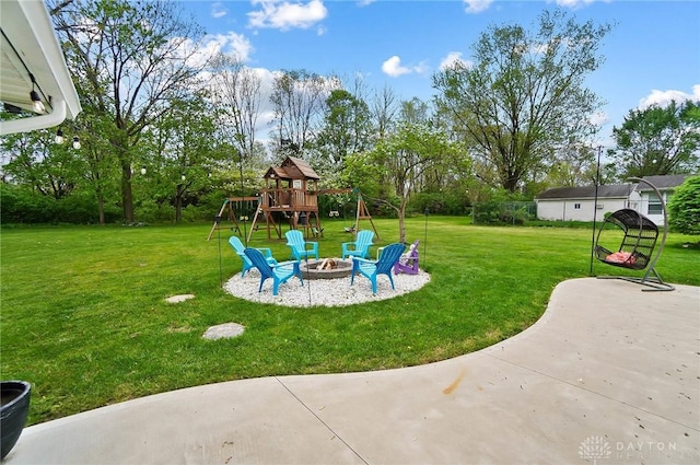 view of yard with a playground, an outdoor fire pit, and a patio area
