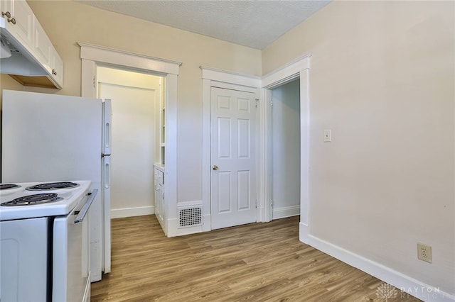 3733-3735 Reading Rd, Cincinnati, OH 45229 - kitchen featuring visible vents, white electric stove, baseboards, white cabinets, and light wood-style flooring