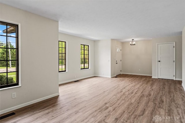 1330 E Centerville Station Rd, Dayton, OH 45459 - unfurnished living room featuring a chandelier, baseboards, visible vents, and wood finished floors