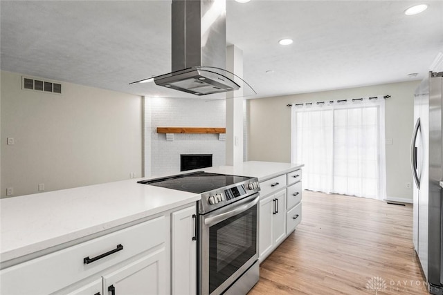 1330 E Centerville Station Rd, Dayton, OH 45459 - kitchen featuring wall chimney range hood, light countertops, stainless steel appliances, white cabinetry, and visible vents