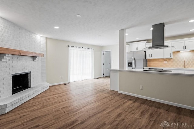 1330 E Centerville Station Rd, Dayton, OH 45459 - kitchen with wood finished floors, white cabinets, stainless steel fridge with ice dispenser, island exhaust hood, and backsplash