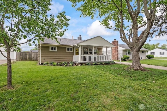 exterior space with fence, a chimney, and a front yard