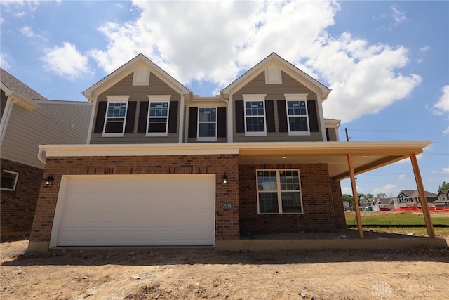 2014 Glen Valley Dr Unit 218, Washington Twp, OH 45458 - view of front of house with brick siding, a garage, dirt driveway, and a porch