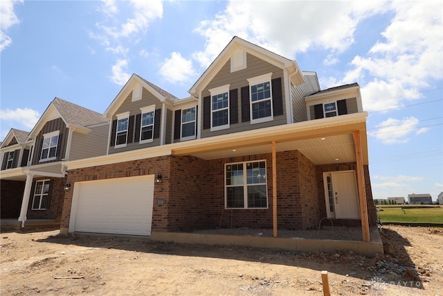2014 Glen Valley Dr Unit 218, Washington Twp, OH 45458 - view of front of property with brick siding, dirt driveway, a garage, and covered porch