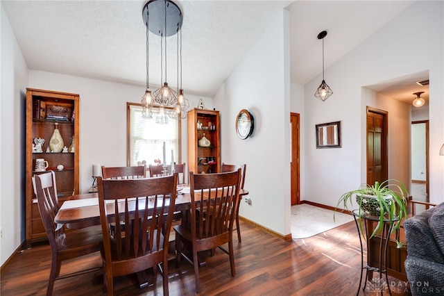 717 Walden Way, Dayton, OH 45440 - dining space featuring vaulted ceiling, a chandelier, baseboards, and dark wood-style floors