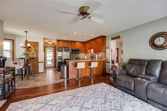 717 Walden Way, Dayton, OH 45440 - living room with wood finished floors, ceiling fan with notable chandelier, and recessed lighting