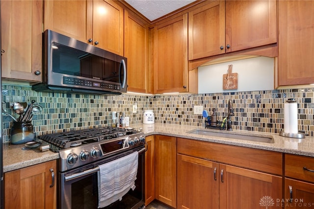 717 Walden Way, Dayton, OH 45440 - kitchen featuring brown cabinetry, light stone counters, a sink, decorative backsplash, and stainless steel appliances
