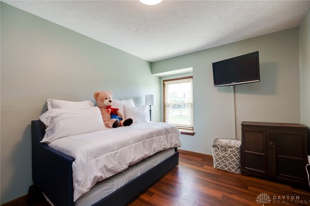 717 Walden Way, Dayton, OH 45440 - bedroom featuring a textured ceiling, dark wood-type flooring, and baseboards