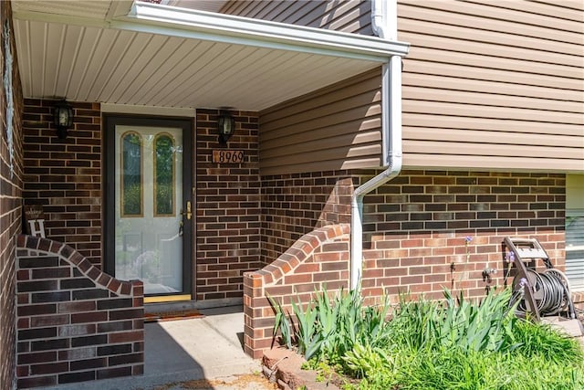 doorway to property with brick siding