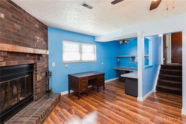 interior space featuring visible vents, wood finished floors, ceiling fan, stairway, and a textured ceiling