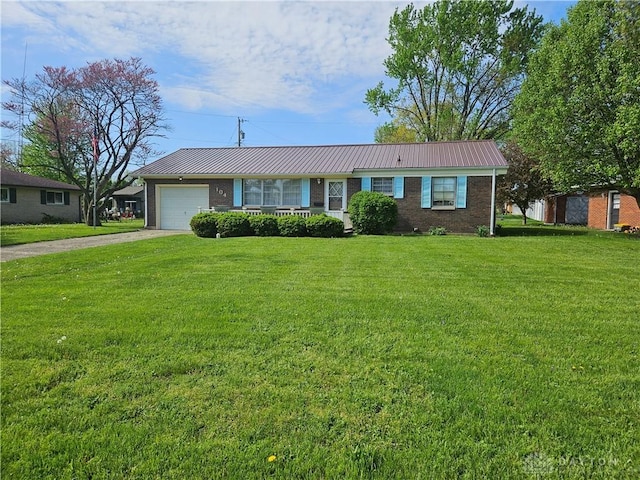 ranch-style home with an attached garage, driveway, a front yard, and metal roof