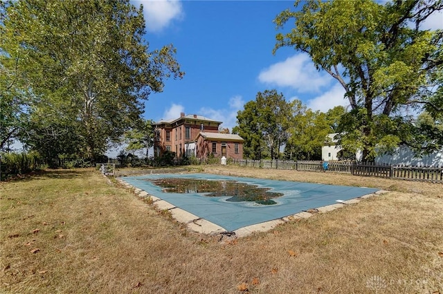 view of pool featuring a lawn and fence