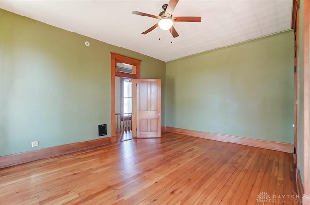 unfurnished room with baseboards, ceiling fan, and light wood-type flooring