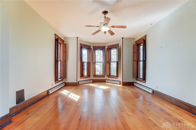 spare room featuring light wood-type flooring, a baseboard radiator, and a ceiling fan