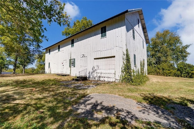 view of side of home with a garage, a yard, and driveway