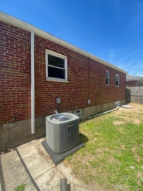 944 Wilmington Ave, Dayton, OH 45420 - rear view of property featuring central AC, brick siding, and fence