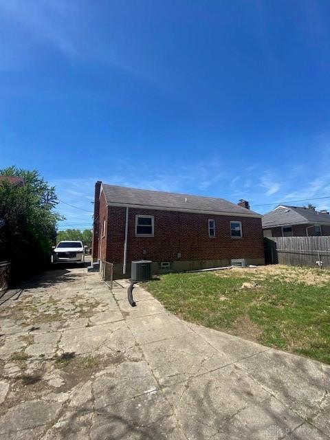 944 Wilmington Ave, Dayton, OH 45420 - back of house featuring central AC, concrete driveway, and brick siding