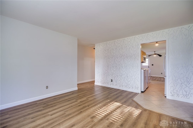 unfurnished room with wallpapered walls, baseboards, and light wood finished floors