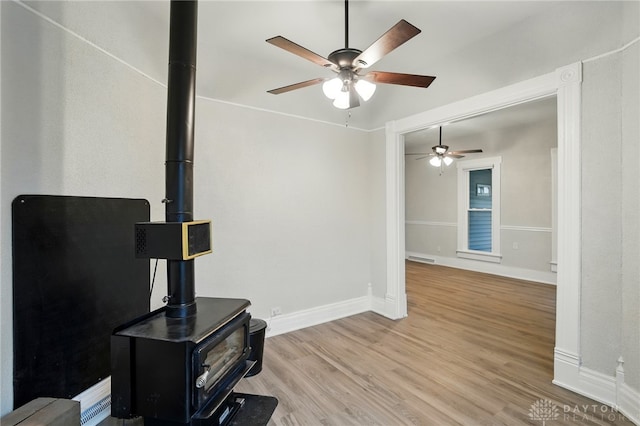 131 Hamilton St, West Milton, OH 45383 - living area featuring a wood stove, a ceiling fan, and wood finished floors