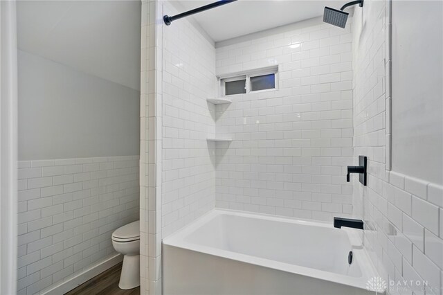 131 Hamilton St, West Milton, OH 45383 - bathroom with tile walls,  shower combination, a wainscoted wall, and wood finished floors
