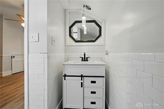 131 Hamilton St, West Milton, OH 45383 - bathroom with tile walls, vanity, wood finished floors, wainscoting, and a ceiling fan