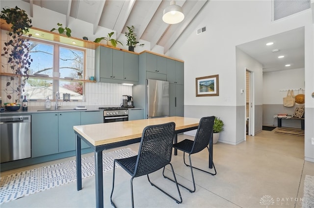 kitchen with stainless steel appliances, visible vents, a sink, and tasteful backsplash