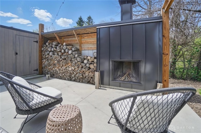 view of patio / terrace featuring fence and a fireplace