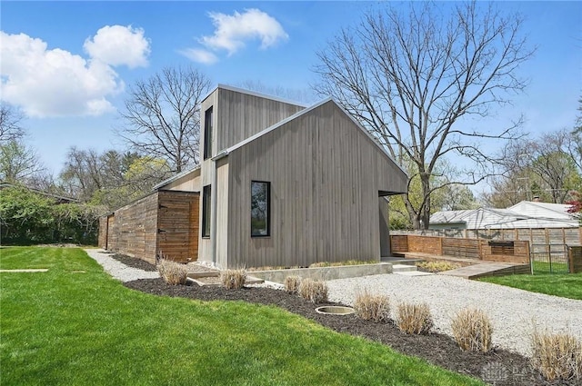 view of side of home with a lawn and fence